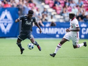 Vancouver Whitecaps' Alphonso Davies, attempts to gain control of the ball while being watched by Toronto FC's Chris Mavinga.  Davies hasn't let his $22 million transfer to Bayern Munich change him at all.