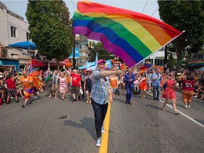 British Columbia Premier John Horgan waves a rainbow flag while marching in the 2017 Vancouver Pride Parade. This year's parade is on Dunday and the weather looks sunny but not too hot.