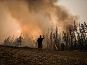 Verne Tom photographs a wildfire burning approximately 20km southwest of Fort St. James, B.C., on Wednesday, August 15, 2018. The British Columbia government has declared a provincial state of emergency to support the response to the more than 500 wildfires burning across the province.