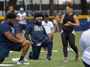 FILE - In this July 28, 2018, file photo, Dallas Cowboys offensive tackle La'el Collins, left and running back Ezekiel Elliott, center, listen to yoga instructor Stacey Hickman, right, as the team does some flexibility exercises at NFL football training camp in Oxnard, Calif.