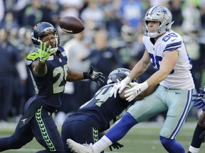 Earl Thomas reaches for the second of his two interceptions in Sunday's win over the Dallas Cowboys.