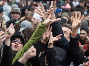 People reach for joints being thrown into the crowd during the 4/20 annual marijuana celebration, in Vancouver, B.C., on Friday April 20, 2018.