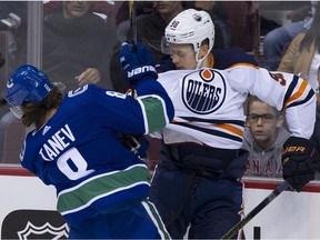 Chris Tanev takes the Edmonton Oilers' Jesse Puljujarvi into the boards in a pre-season game on Tuesday.