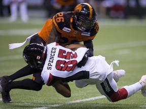 BC Lions defensive back Anthony Orange (26) tackles Ottawa Redblacks wide receiver Diontae Spencer (85) during the first half of CFL football action in Vancouver, B.C., on Friday, Sept. 7, 2018.