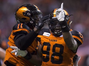 B.C. Lions' defensive end Ivan McLennan, right, celebrates sacking Ottawa Redblacks' quarterback Trevor Harris with his teammate Odell Willis during Friday's CFL game at B.C. Place Stadium in Vancouver. The Lions won the game 26-14.