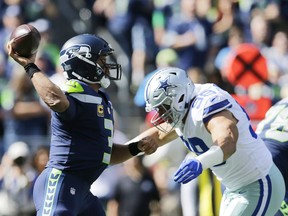 Seattle Seahawks quarterback Russell Wilson prepares to pass as Dallas Cowboys defensive end Tyrone Crawford, right, moves in for a hit during the first half of an NFL football game, Sunday, Sept. 23, 2018, in Seattle.