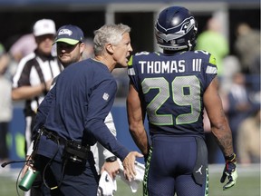 Seattle Seahawks head coach Pete Carroll, left, talks with free safety Earl Thomas during the first half of an NFL football game against the Dallas Cowboys, Sunday, Sept. 23, 2018, in Seattle.