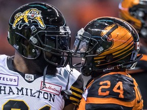Hamilton Tiger-Cat Simoni Lawrence (left) and B.C. Lion Jeremiah Johnson exchange words after Lawrence tackled Johnson during the first half of their CFL game at B.C. Place Stadium on Sept. 22, 2018.