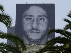 Palm trees frame a large billboard on top of a Nike store that shows former San Francisco 49ers quarterback Colin Kaepernick at Union Square on Sept. 5, 2018, in San Francisco. An endorsement deal between Nike and Colin Kaepernick has prompted a flood of debate as sports fans reacted to the apparel giant backing an athlete known mainly for starting a wave of protests among NFL players of police brutality, racial inequality and other social issues.