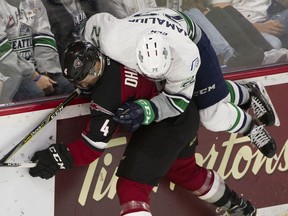 Defenceman Bailey Dhaliwal of the Vancouver Giants, who left Friday's WHL game against the Seattle Thunderbirds with his shoulder in a sling, is jumped on by Dilon Hamaliuk of the T-Birds at Langley Events Centre.