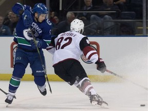 Vancouver Canucks' Nikolay Goldobin (77) try to get around Arizona Coyotes' Jordan Oesterle (82) during first period preseason action in Kelowna on Saturday.