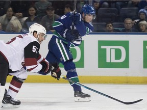 The Coyotes' Jason Demers gets in front of Canucks' centre Elias Pettersson.