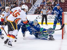 Calgary Flames' Spencer Foo (15) scores against Vancouver Canucks goalie Thatcher Demko (35) during the first period of a pre-season NHL hockey game in Vancouver, B.C., on Wednesday September 19, 2018.