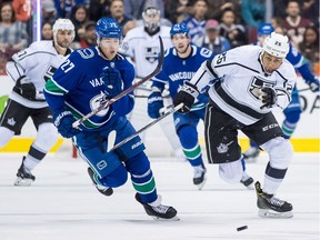Vancouver Canucks' Ben Hutton (27) and Los Angeles Kings' Emerson Etem (26) skate after the puck during the first period of a pre-season NHL hockey game in Vancouver, B.C., on Thursday September 20, 2018.