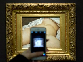 In this Feb. 12 2016 file photo, a visitor takes a picture of Gustave Courbet's 1866 "The Origin of the World," at Musee d'Orsay museum, in Paris.