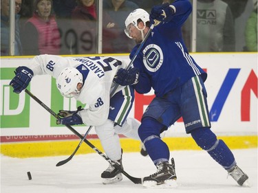 Michael Carcone (left) and Erik Gudbranson fighting for the puck during a scrimmage at Vancouver Canucks 2018 training camp at the Meadow Park Sports Centre in Whistler, BC Saturday, September 15, 2018.