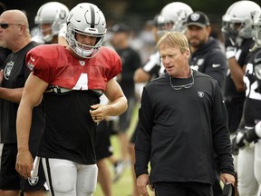 Oakland Raiders head coach Jon Gruden (right) talks with quarterback Derek Carr during a team practice in Napa, Calif, on Aug. 8, 2018.