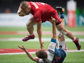 Canada's Harry Jones, top, collides with France's Thibauld Mazzoleni while running with the ball during World Rugby Sevens Series action, in Vancouver, B.C., on Sunday March 11, 2018. Rugby Canada's plan to have one centralized pool of men's players rather than having separate 15s and sevens training squads is off to a rocky start.