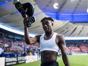 Alphonso Davies reaches up to give his jersey to a fan after the Caps' 2-1 win over the San Jose Earthquakes at B.C. Place Stadium on Sept. 1, 2018.