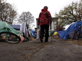 A resident walks down a path at the homeless camp in Victoria, B.C., in an April 5, 2016, file photo. As many as 75 people moved to a new site in Saanich on Friday, after a court injunction forced them out of Regina Park, roughly 500 metres away.