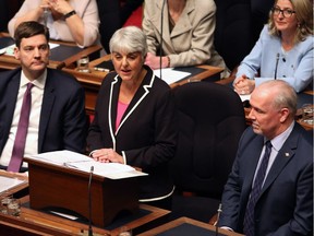 B.C. Finance Minister Carole James, flanked by Attorney General David Eby (left) and Premier John Horgan (right), delivers last February’s budget speech in the legislature. On Tuesday, James tabled the controversial speculation tax.