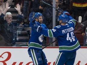 Nikolay Goldobin celebrates with teammate Elias Pettersson after scoring a goal.