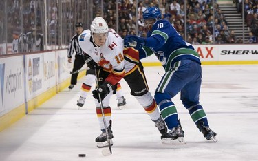 Brandon Sutter #20 of the Vancouver Canucks tries to check Matthew Tkachuk #19 of the Calgary Flames off the puck in NHL action on October, 3, 2018 at Rogers Arena in Vancouver, British Columbia, Canada.