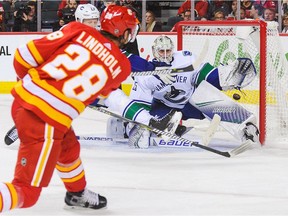 Elias Lindholm of the Flames scores the winner against Jacob Markstrom of the Vancouver Canucks during NHL action at the Scotiabank Saddledome on Oct. 6 in Calgary.
