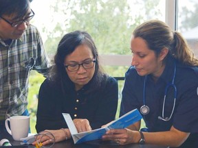 Paramedic Tali Loewen shows the Emergency Medical Translator to a couple. (Submitted photo) [PNG Merlin Archive]