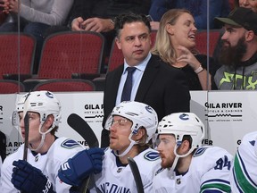 Head coach Travis Green of the Vancouver Canucks watches from the bench during an NHL game.