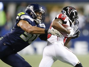 Linebacker K.J. Wright of the Seattle Seahawks tackles wide receiver Taylor Gabriel of the Atlanta Falcons during the third quarter of the game at CenturyLink Field on November 20, 2017 in Seattle, Washington.