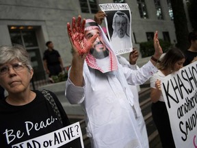 A demonstrator dressed as Saudi Arabian Crown Prince Mohammed bin Salman (C) with blood on his hands protests outside the Saudi Embassy in Washington, DC, on October 8, 2018, demanding justice for missing Saudi journalist Jamal Khashoggi.