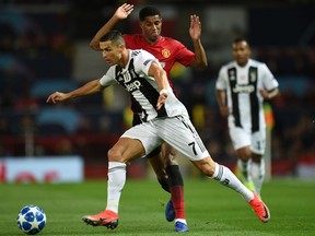 Cristiano Ronaldo of Juventus keeps Manchester United's Marcus Rashford at bay during their Champions League Group H match at Old Trafford in Manchester, England, on Oct. 23, 2018.