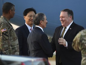 U.S. Secretary of State Mike Pompeo, right, is greeted by U.S. Ambassador to South Korea Harry Harris upon his arrival at Osan Air Base in Pyeongtaek, in South Korea, Sunday, Oct. 7, 2018, after his North Korea trip. Pompeo has wrapped up his fourth visit to North Korea after meeting Kim Jong Un to seek elusive progress in efforts to persuade him to give up his nuclear weapons.