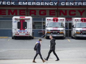 FILE PHOTO People walk past ambulances in the Emergency bay at St. Paul's Hospital in Vancouver, B.C.