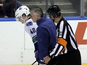 Vancouver Canucks star rookie centre Elias Pettersson is helped off the ice by a team trainer and official after being driven to the ice by Florida Panthers blueliner Mike Matheson during Saturday’s NHL game in Sunrise, Fla.