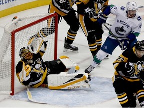 Penguins goalie Casey DeSmith flops around the crease as Canuck Tim Schaller awaits a rebound during the first period. Defenceman Ben Hutton would score on the play.