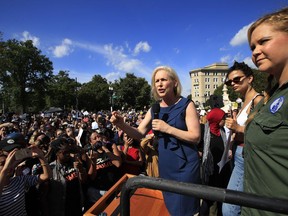 Sen. Kirsten Gillibrand, D-N.Y., with actress and comedian Amy Schumer, right, and actress model Emily Ratajkowski, center, speaks at a rally against Supreme Court nominee Brett Kavanaugh at the Supreme Court in Washington, Thursday, Oct. 4, 2018.