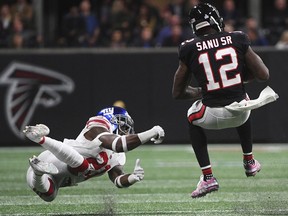 New York Giants strong safety Landon Collins (21) trips up Atlanta Falcons wide receiver Mohamed Sanu (12) during the second half of an NFL football game, Monday, Oct. 22, 2018, in Atlanta.