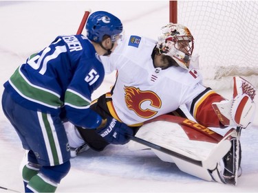 Calgary Flames goaltender Mike Smith (41) stops a shot from Vancouver Canucks defenseman Troy Stecher (51) during second period NHL action at Rogers Arena in Vancouver, Wednesday, Oct, 3, 2018.