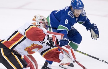 Vancouver Canucks left wing Brendan Leipsic (9) fight for control of the puck with Calgary Flames goaltender Mike Smith (41) during third period NHL action at Rogers Arena in Vancouver, Wednesday, Oct, 3, 2018.