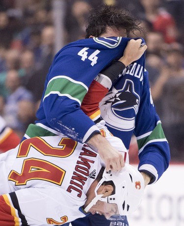 Vancouver Canucks defenseman Erik Gudbranson (44) fights with Calgary Flames defenseman Travis Hamonic (24) during first period NHL action at Rogers Arena in Vancouver, Wednesday, Oct, 3, 2018.
