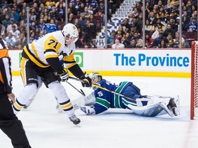 Vancouver Canucks goalie Jacob Markstrom stops Pittsburgh Penguins' Evgeni Malkin in the first period, but he couldn't do it all himself as the Pens poured it on in the third for a 5-0 win.