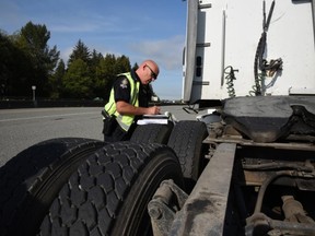 Nearly half the commercial vehicles inspected during a safety blitz last month in Delta were pulled off the road for being unsafe, resulting in nearly $40,000 in fines and tickets. Const. Ken Usipiuk with the Delta Police is pictured writing a ticket for the driver of a commercial truck that has been pulled over.