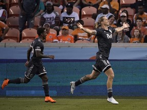 Vancouver Whitecaps's Brek Shea, right, celebrates with Yordy Reyna, left, after scoring a what would end up being the game winner against the Houston Dynamo Saturday last March in Houston.