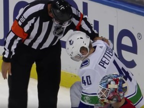 An official checks on the status of Vancouver Canucks rookie Elias Pettersson after Florida Panthers’ defenceman Mike Matheson drove him into the ice on Saturday night.