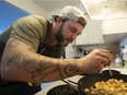 Chef Travis Petersen adds THC infused oil to the potatoes he is preparing while making a chicken noodle soup with THC and CBD in Vancouver.