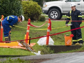 An official decontaminates his boots after exiting a ditch while investigating the source of an odour complaint in a North Surrey, BC, neighbourhood October, 7, 2018.