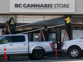 Workers replace the old signage outside the B.C. Cannabis Store in Kamloops, BC, October, 16, 2018.
