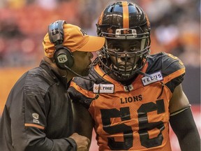 Mark Washington, the defensive coordinator of the B.C. Lions, huddles with linebacker Solomon Elimimian on the sidelines. With a win Friday against the visiting Eskimos the Lions can clinch a playoff berth.